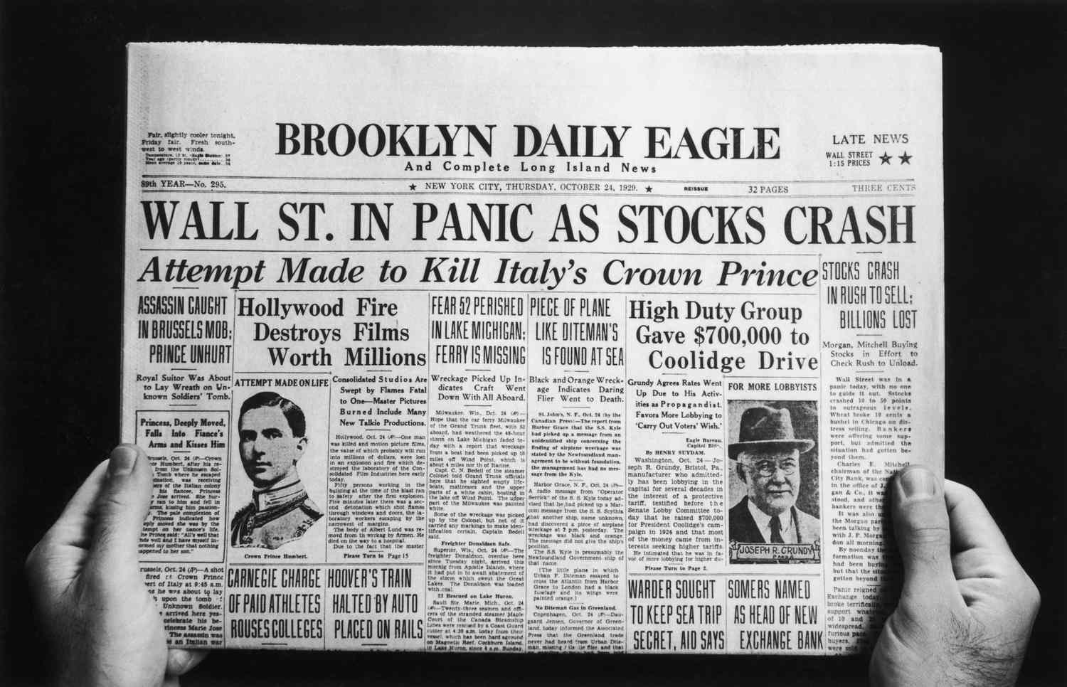 Hands holding the Brooklyn Daily Eagle front page of Thursday, October 24, 1929, headed Wall St. in Panic as Stocks Crash